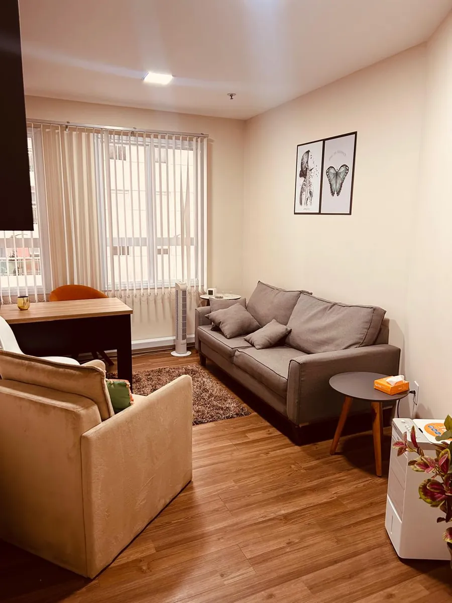 Sala de atendimento do consultório da Thaize Netto em Barueri, com sofás e quadros na parede